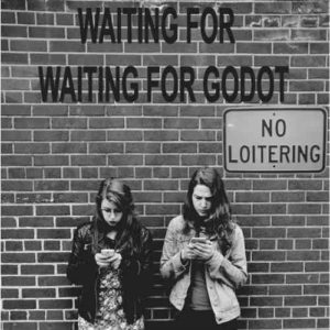 two women on cell phones, under a no loitering sign