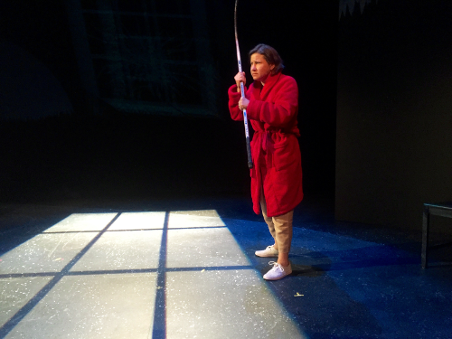 Melanie Lepp in a red robe holding a hockey stick