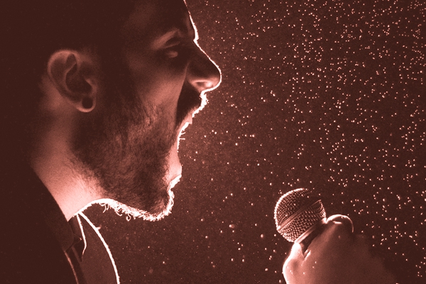 Image of a man hollering into a microphone