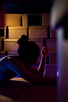 Photo of Mateo Galindo Torres by Vish Hansa in Jacqueries Part 2 - image of silhouetted person leaning on elbows on a box, surrounded by more boxes