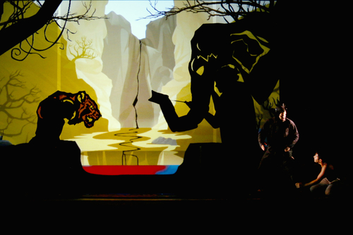 image of two people in the bottom right of a large set with a shadow of an elephant and a jaguar - from Jungle Book at YPT Photo of Matt Lacas and Levin Valayil and by Rick Miller.