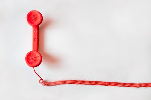 Photo of red phone handset with cord by Negative Space